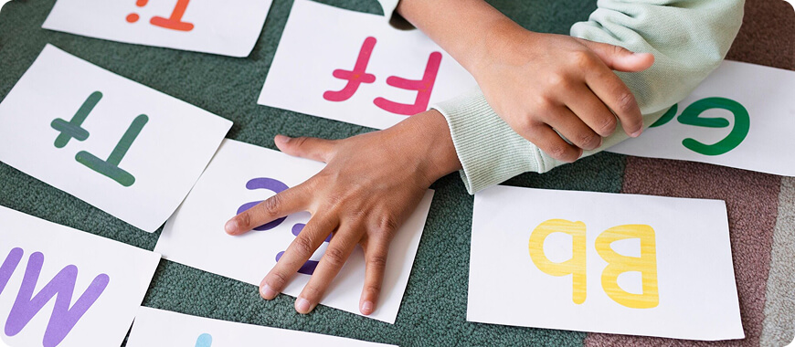 Child interacting with alphabet cards to assess English language skills