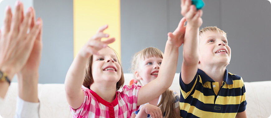 Happy kids learning possessive adjectives like 'my', 'your', 'his', 'her' in a fun English class